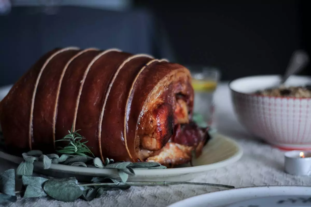 Porchetta fatiada sobre tábua de madeira